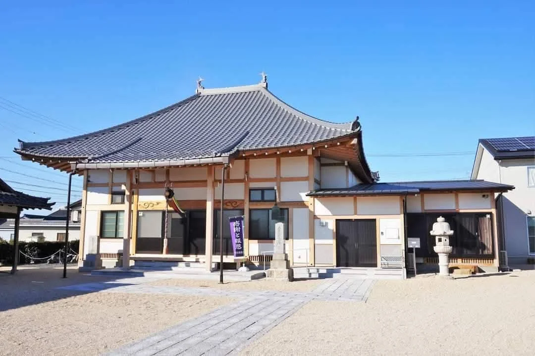 木の回廊に面した寺院の建物と庭木の見える外観