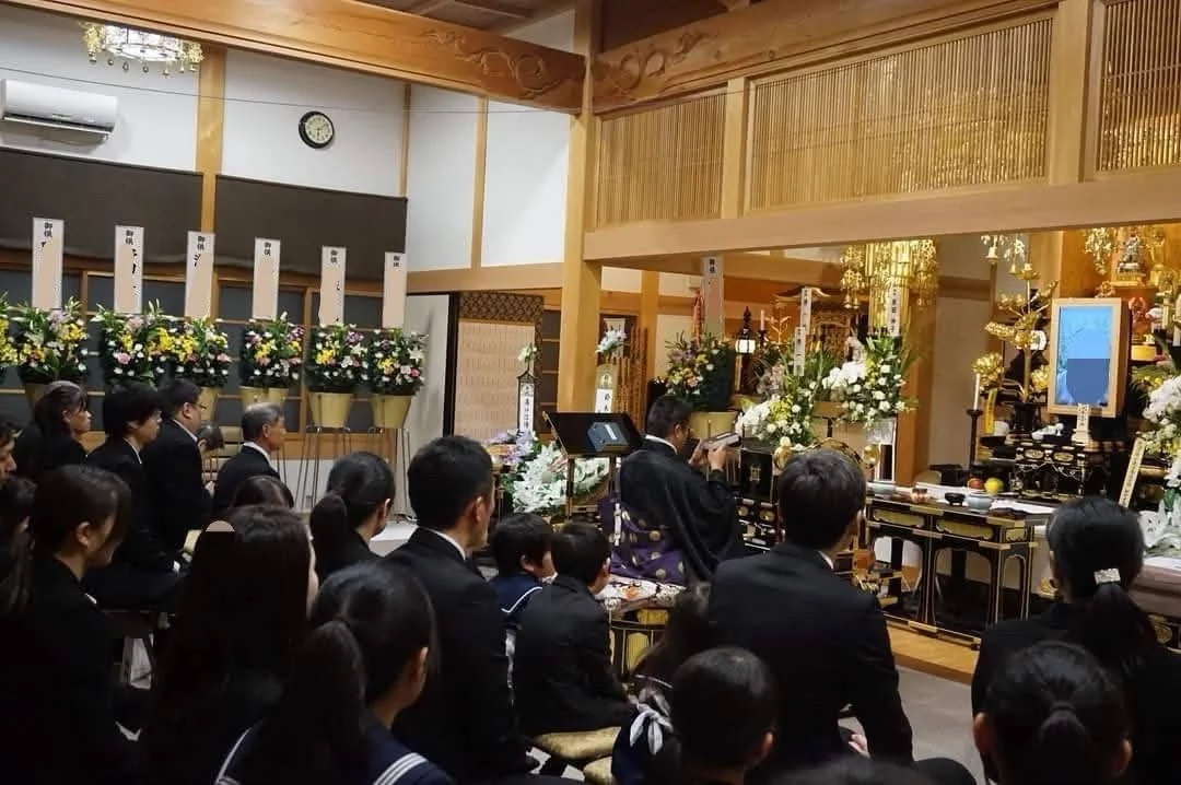 妙福寺の本堂で行われる葬儀の読経風景